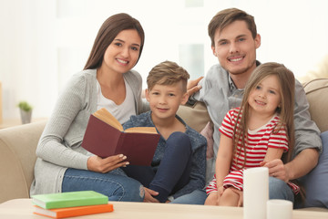 Happy family reading book together at home