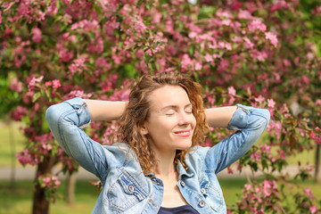 Portrait of beautiful woman near blooming tree in park