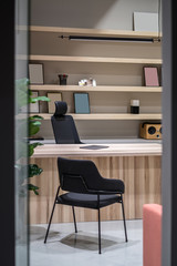 Stylish office with wooden table and shelves