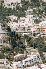 Naklejka premium The coast of Positano, Amalfi in Italy. Panorama of the evening city and the streets with shops and cafes. Houses by the sea and the beach. Ancient architecture and temples