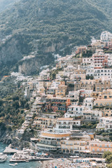 The coast of Positano, Amalfi in Italy. Panorama of the evening city and the streets with shops and cafes. Houses by the sea and the beach. Ancient architecture and temples