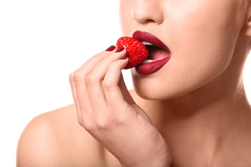 Sexy young woman with strawberry on white background, closeup