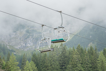 A chairlift with mountains and fog in the background