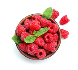 Bowl with ripe raspberries on white background
