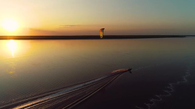 The setting sun above the lake, the wakeboard splashing on the water