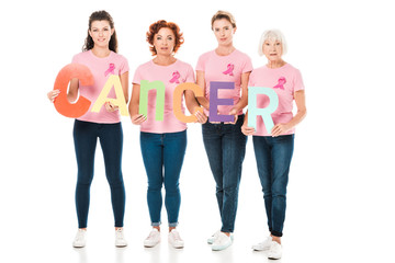 women in pink t-shirts with breast cancer awareness ribbons holding colorful letters with word...