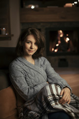 Pretty Woman Sitting by the Fireplace