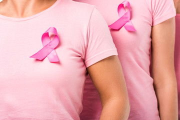 cropped shot of women in pink t-shirts with breast cancer awareness ribbons