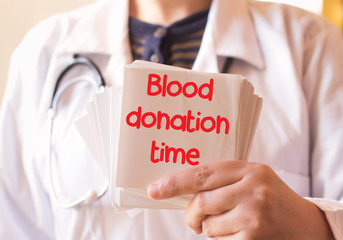 Doctor holding small paper with blood donation time