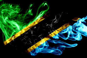 National flag of Tanzania made from colored smoke isolated on black background. Abstract silky wave background.