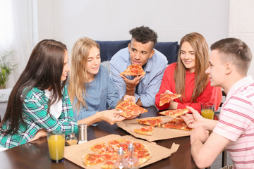 Young people having fun at party with delicious pizza indoors