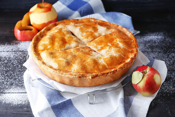 Cooling rack with delicious apple pie on wooden table