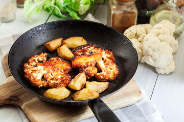 Vegetarian roasted cauliflower steak with herbsand fried potatoes