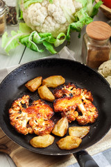 Vegetarian roasted cauliflower steak with herbsand fried potatoes