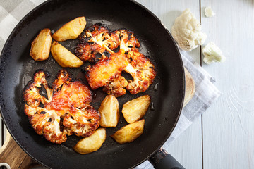 Vegetarian roasted cauliflower steak with herbsand fried potatoes
