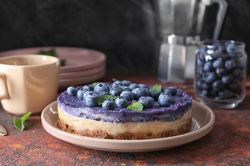 Plate with delicious blueberry cheesecake on table