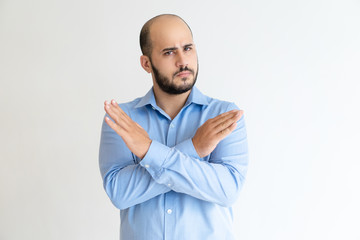 Strict man showing crossed hands and looking at camera. Guy frowning and denying something....