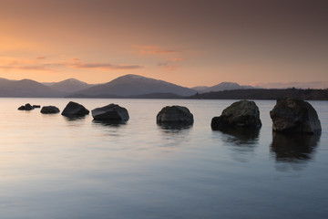Fototapeta na wymiar Stones in Loch Lomond at Millarochy Bay in Scotland. Taken at sunset.