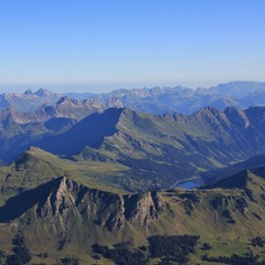 Lake Arnen and mountain ranges on a summer morning. View from Glacier 3000, Switzerland.