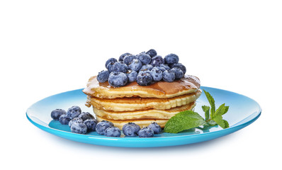 Plate with tasty pancakes and blueberries on white background