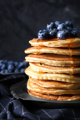 Plate with tasty pancakes and blueberries on table, closeup