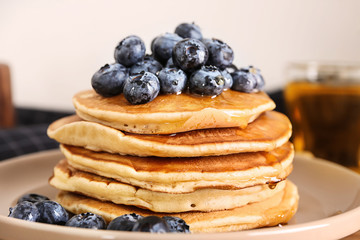 Tasty pancakes with blueberries on plate, closeup