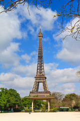 Beautiful vibrant spring view of the Eiffel tower in Paris, France, with a blue sky and some clouds