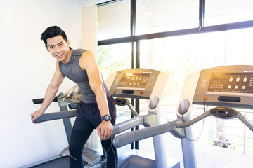 Fototapeta na wymiar Portrait of happy mature men on treadmill in fitness center