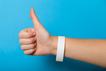 White blank bracelet on hand. Music festival branding wristband, adhesive paper accessory