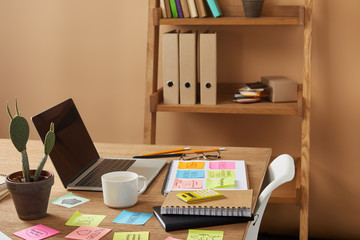 paper stickers with business strategy, cactus and laptop on tabletop