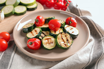 Tasty grilled zucchini with tomatoes on plate