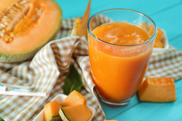 Glass of fresh melon smoothie on table, closeup