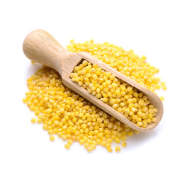 Raw uncooked millet in a wooden scoopr