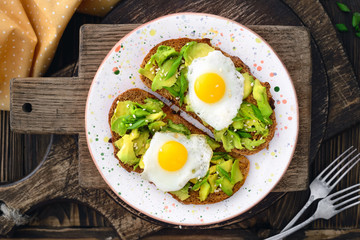 avocado quail egg sandwiches in a plate on a wooden background