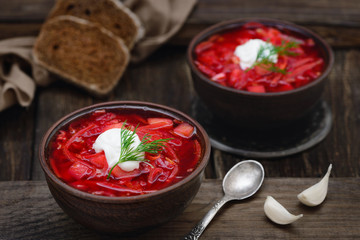 Vegan borscht in bowls on an old wooden background