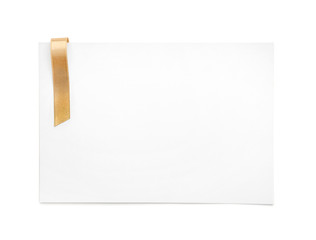 Blank paper card with golden ribbon on white background