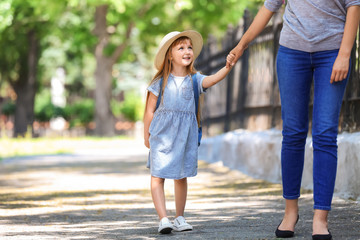 Fototapeta premium Cute little girl going to school with her mother