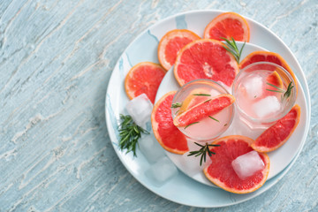 Fresh grapefruit cocktail with rosemary in glasses on plates