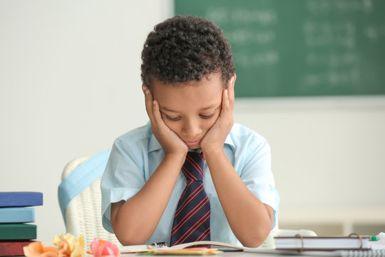 Bored African-American Boy Unwilling To Study In Classroom