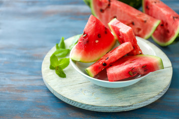 Bowl with slices of watermelon on table