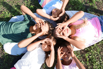 Cute little children lying on green grass outdoors