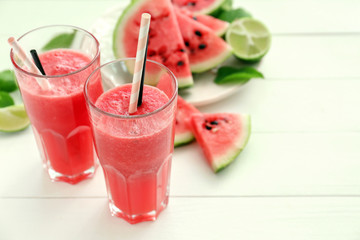 Glasses with fresh watermelon smoothie on white table