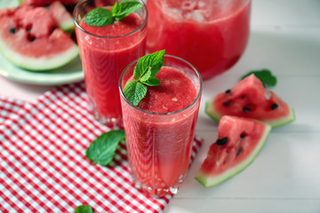 Glasses with fresh watermelon smoothie on table