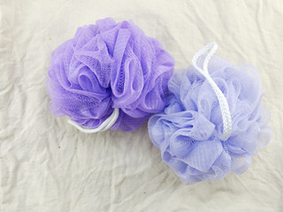 Obraz na płótnie Canvas purple and blue plastic bath puff for shower cleaning and scrub body