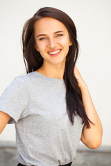 Fototapeta premium Happy brunette woman in gray t-shirt