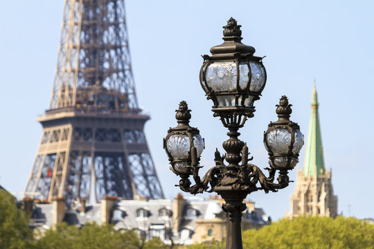 Ancient ornate lantern in Paris, France, with the Eiffel tower in the background on a spring day