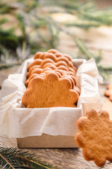 Sweet thin ginger biscuit in gift box on a wooden background. Festive pastry.