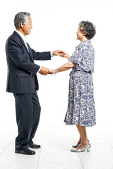 Grandfather and grandmother hand in hand together dancing cheerfully in white background