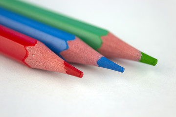 red, blue and green pencils lie on a light background