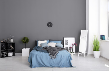 Room interior with big mirror and comfortable bed